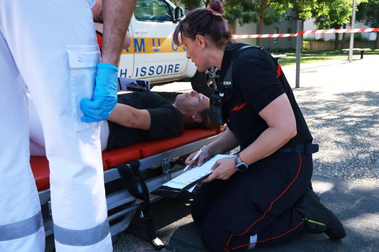 Pompier prenant en charge un patient sur un brancard
